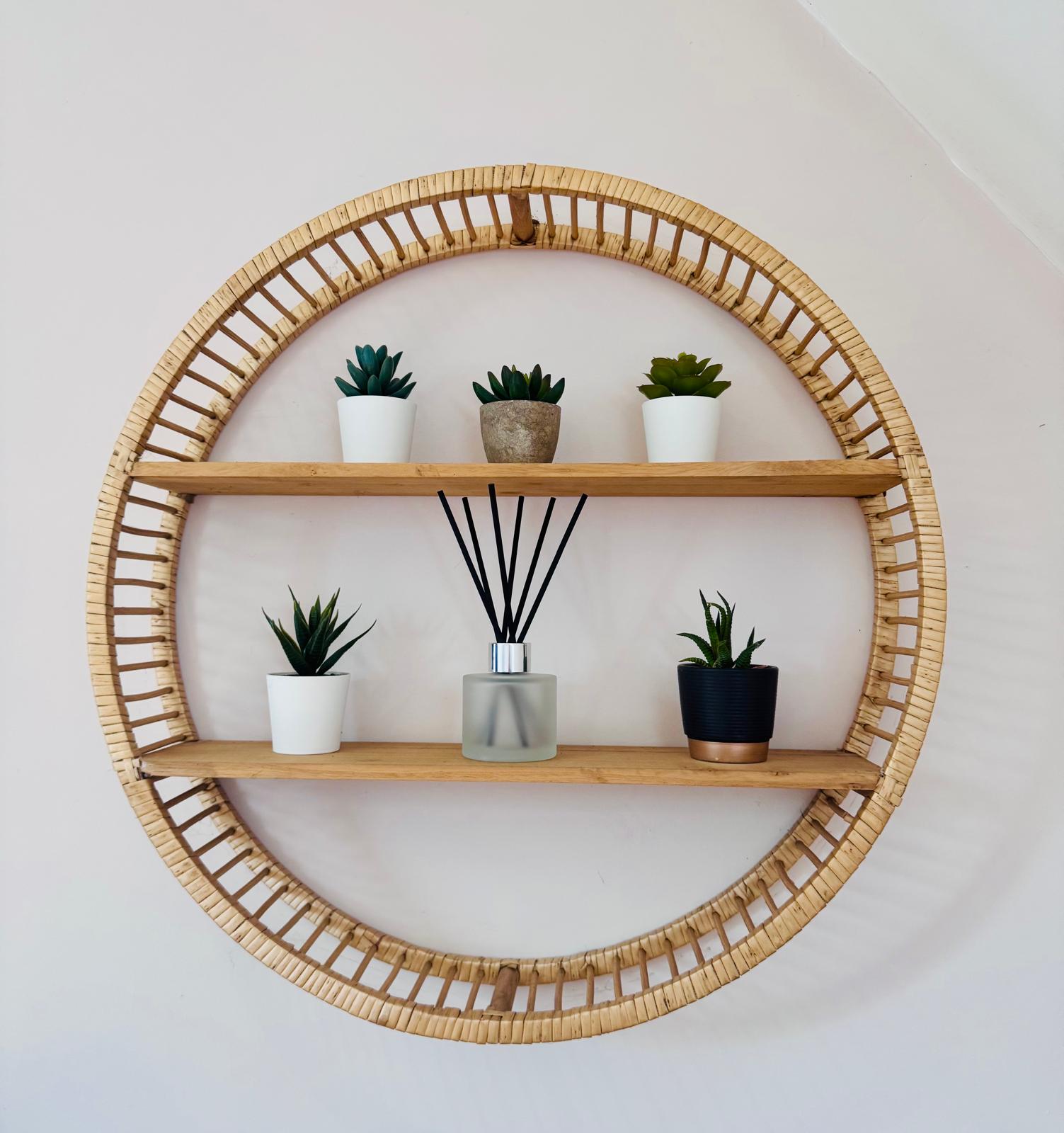 Round rattan wall shelf with decorative items on a white wall