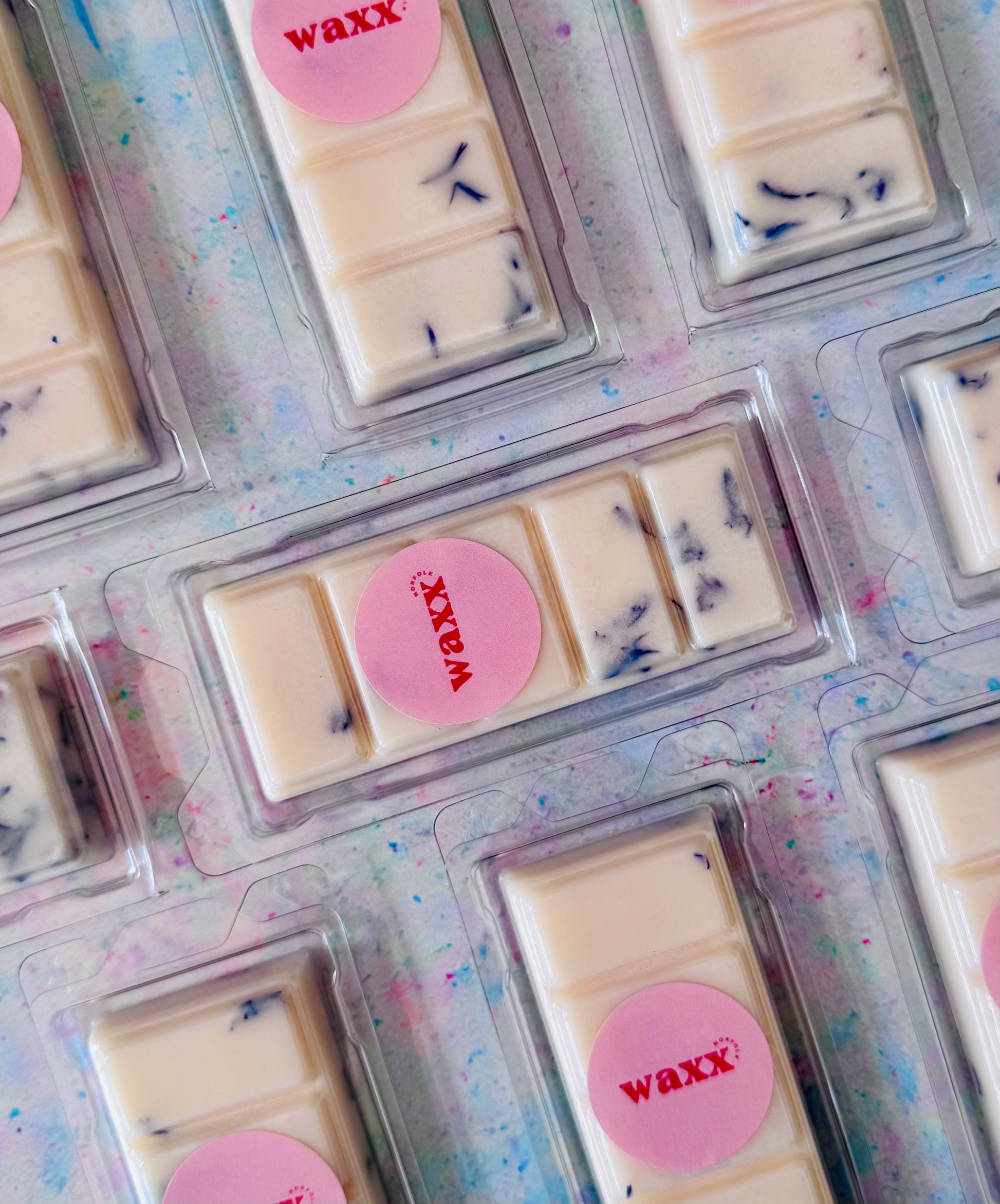 Wax bars in clear packaging with 'WAXX' label on a colorful background